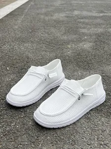 Dettaglio di mocassini in velluto a coste bianco con lacetti decorativi e design slip-on.
