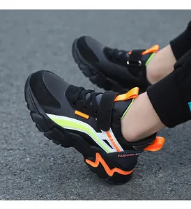 Close-up of children's black sneakers with neon green and orange sporty accents