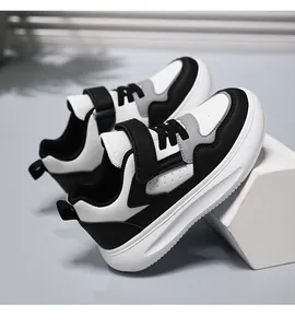 Vista lateral detallada de zapatillas de cuero para niños en soporte geométrico