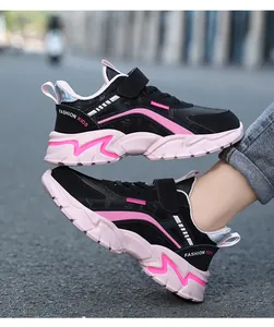 Detailed side view of black and pink girls sports sneakers with velcro strap and durable sole