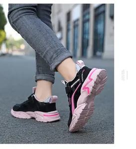 Side view of child wearing pink and black lightweight running sneakers outdoors