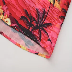 Detalle de las costuras del dobladillo y estampado de palmeras en una camisa hawaiana roja
