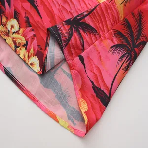 Detalle de cerca del estampado tropical de palmeras y costuras de camisa hawaiana roja.