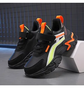 Close-up of black kids running sneakers with vibrant orange and lime green accents