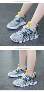 Close-up view of breathable mesh boys' sneakers with 'SUP' design worn by a child model.