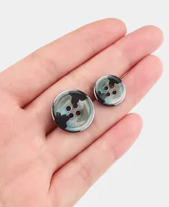 Detailed close-up of natural black mop shell buttons with unique camouflage patterns.