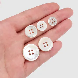 Boutons en nacre naturelle de haute qualité en plusieurs tailles tenus dans la main