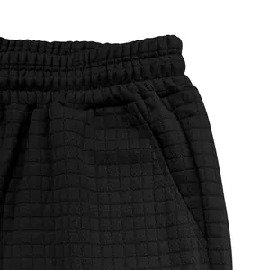 Nahaufnahme der schwarzen Herren-Shorts mit Waffelgitter-Struktur und elastischem Bund.