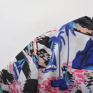 Detalle de una camisa hawaiana de hombre con vibrante estampado de palmeras y barcos.