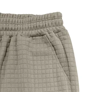 Detaillierte Nahaufnahme von beigem Waffelstrickstoff und Elastikbund bei Herren-Shorts