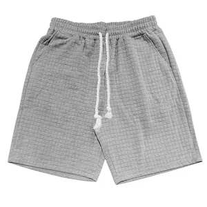 Hochauflösendes Detail der grauen Steppstruktur und des Kordelzugs dieser lässigen Herrenshorts.