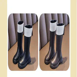 Side view of children's black and white British style tall boots featuring thick soles