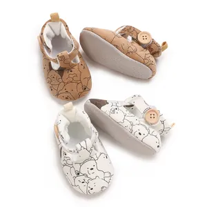 Close-up detail of cute cartoon bear patterns on soft-soled baby princess walking shoes.