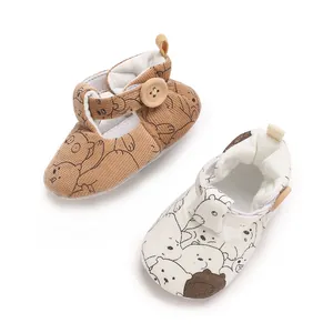 Detail of cartoon bear baby pre-walker shoes in brown corduroy and white fabric textures.
