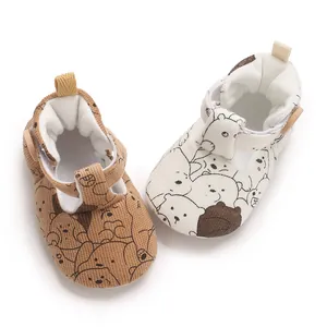 Close-up detail of infant soft-sole walking shoes featuring cute cartoon bear patterns