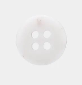 Macro view of a white four-hole eco-friendly resin button for shirts and polo tops