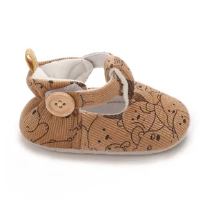 Close-up detail of soft-sole baby walking shoe with cartoon bear print and button
