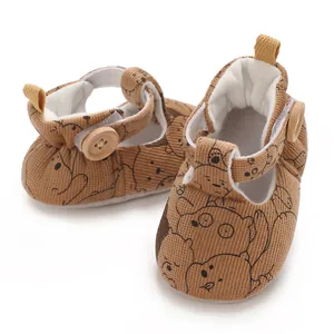 Close-up of soft-sole baby pre-walker shoes featuring cartoon bear patterns and wooden buttons