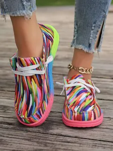Detailansicht von bunten Damen-Canvas-Loafers im Ethno-Stil auf einem Außenholzsteg.