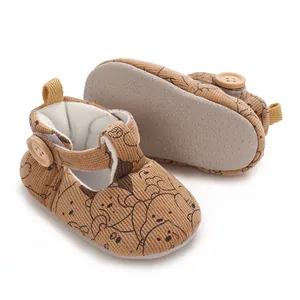 Macro view of corduroy baby shoes featuring a cute cartoon bear print and soft sole.