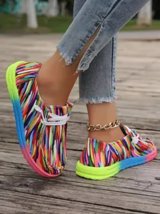 Bunte Canvas-Loafer mit Regenbogen-Sohle auf einem Holzdeck für modebewusste Damen
