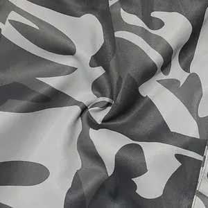 Vue macro détaillée montrant la texture et le motif camouflage gris du tissu tissé pour pantalons