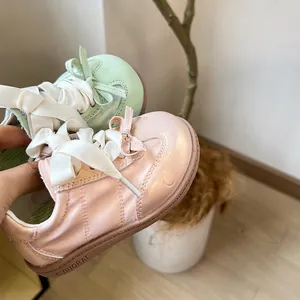 Détail macro de chaussures d'entraînement pour tout-petits roses et vertes avec lacets en satin