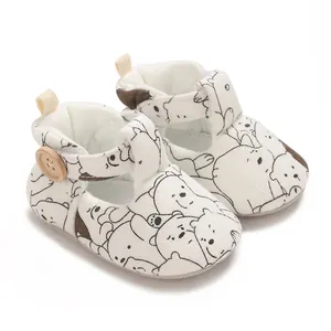 Close-up of white baby walker shoes with black and white cartoon bear patterns