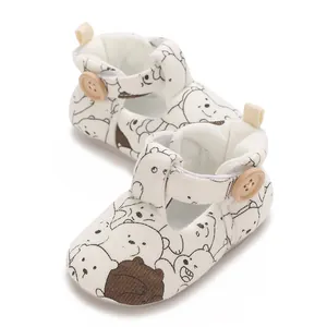 Close-up of baby shoes with cartoon bear pattern and natural wooden button detail
