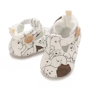 Close-up detail of cartoon bear pattern on white soft-sole baby walking shoes.
