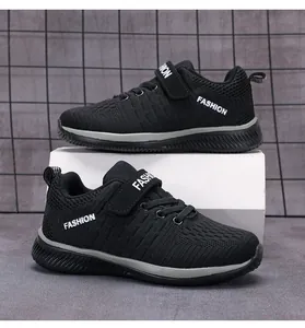 Side view of black boys breathable mesh running sneakers with Velcro straps and white text