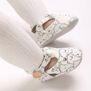 Close-up detail of baby pre-walker shoes with cute cartoon bear pattern and soft sole.
