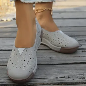 Primer plano de mocasines grises calados con motivos florales en una plataforma