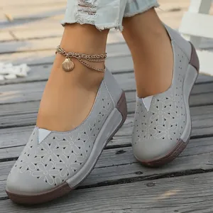 Primer plano detallado de mocasines retro grises con diseño de flores caladas y tobillera