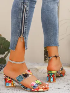 Close-up of women's colorful mosaic block heel slippers with transparent straps.