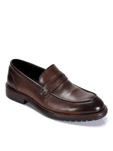 Gedetailleerd zijaanzicht van klassieke bruine leren herenloafers met zachte korrelafwerking