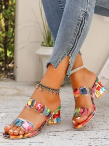 Detailed view of women's colorful gemstone-patterned transparent strap mid-heel sandals