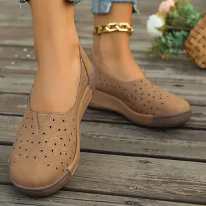 Primer plano de mocasines vintage marrones para mujer con un elegante diseño floral calado