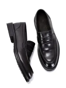 Gedetailleerd overzicht van klassieke zwarte heren loafers van leer met stiksel