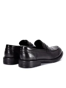 Gedetailleerd achteraanzicht van handgemaakte zwarte leren loafers voor heren met hak