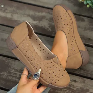 Primer plano detallado del diseño floral calado retro en mocasines planos beige