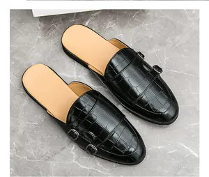 Gros plan de mocassins noirs pour hommes à motif crocodile avec d'élégantes doubles boucles.