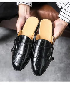 Gros plan de mules pour hommes en cuir noir à motif crocodile avec double boucle