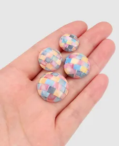 Detailansicht hochwertiger bunter Mosaik-Muschelknöpfe in der Hand für den Größenvergleich