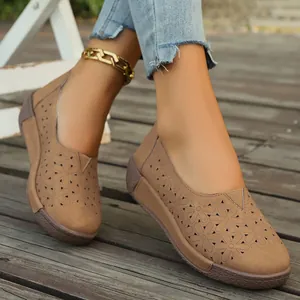 Dettaglio ravvicinato di scarpe basse da donna color cuoio con design traforato