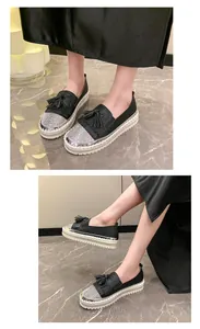 Close-up of women's black platform loafers featuring rhinestone toes and tassel details