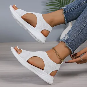Side detail view of stylish white mesh peep-toe wedge sandals worn by a model indoors