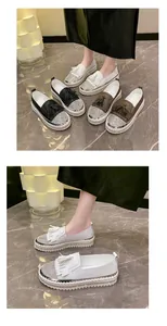 Detailed close-up view of shimmering rhinestone toe and tassel on white platform loafers