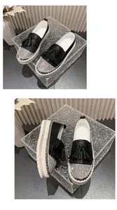 Detailed macro view of stylish black rhinestone loafers featuring tassels and platform soles