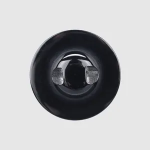 Detail view of a glossy black shell button for high-end coats and luxury trench coats